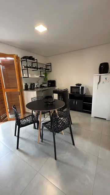 Apartamento de 2 quartos em Maresias: sala com mesa de jantar e cozinha integrada
