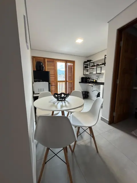 Sala com mesa e cozinha ao fundo